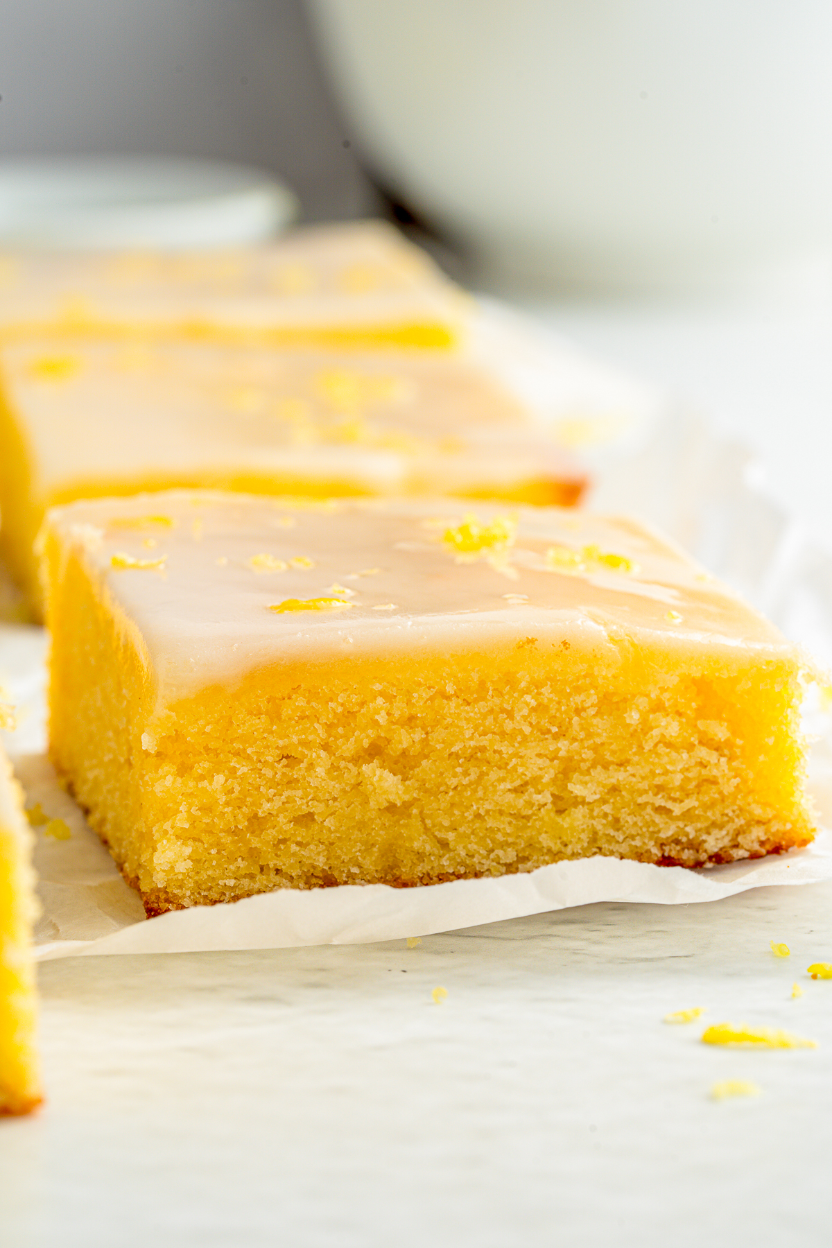 Close up of one Lemon Brownie on parchment paper.