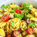 Close up of Tortellini Pasta Salad in bowl showing mixed ingredients.
