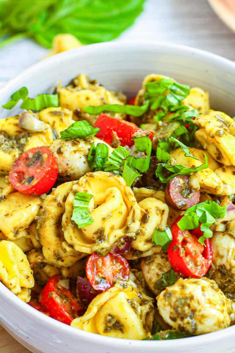 Close up of Tortellini Pasta Salad in bowl showing mixed ingredients.