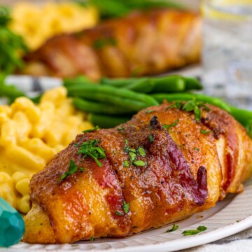 Close up of a piece of Brown Sugar Bacon Wrapped Chicken on plate.
