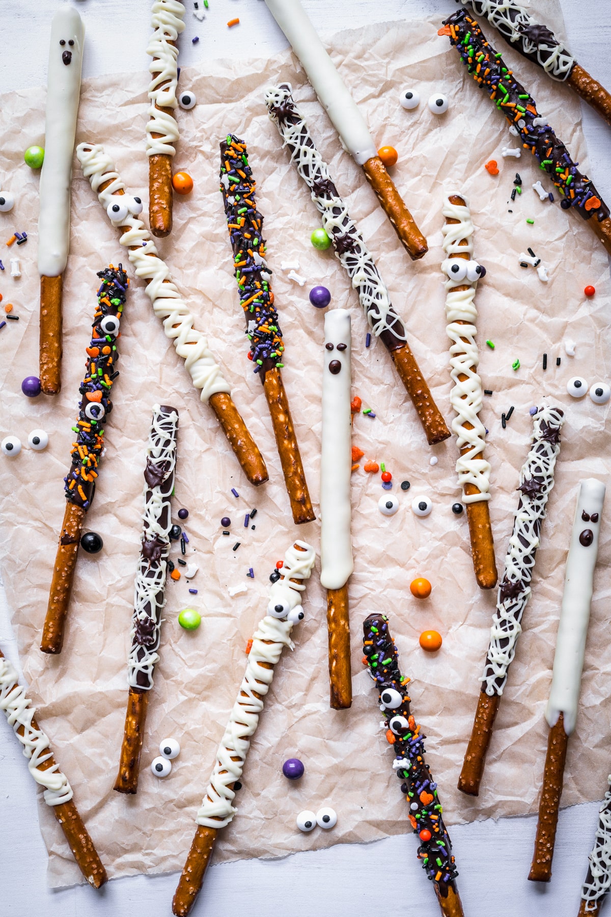 Overhead of finished Halloween Chocolate Pretzel Rods on parchment paper in all forms.