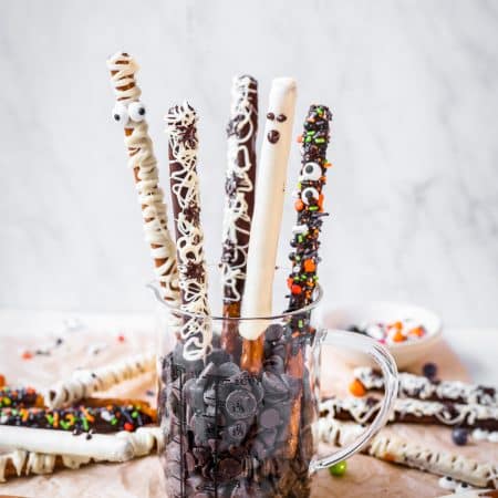 Pretzel Rods in mug of chocolate chips standing up.