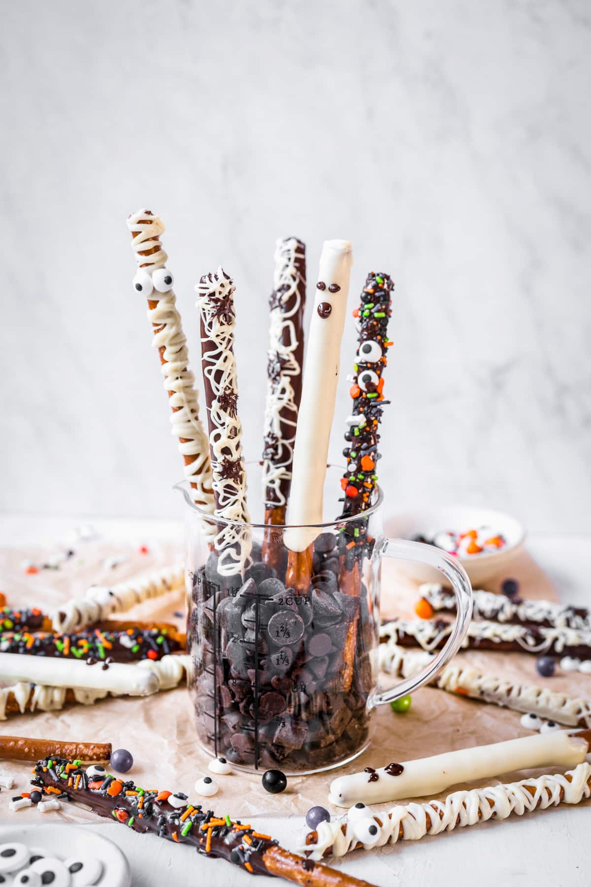 Pretzel Rods in mug of chocolate chips standing up.