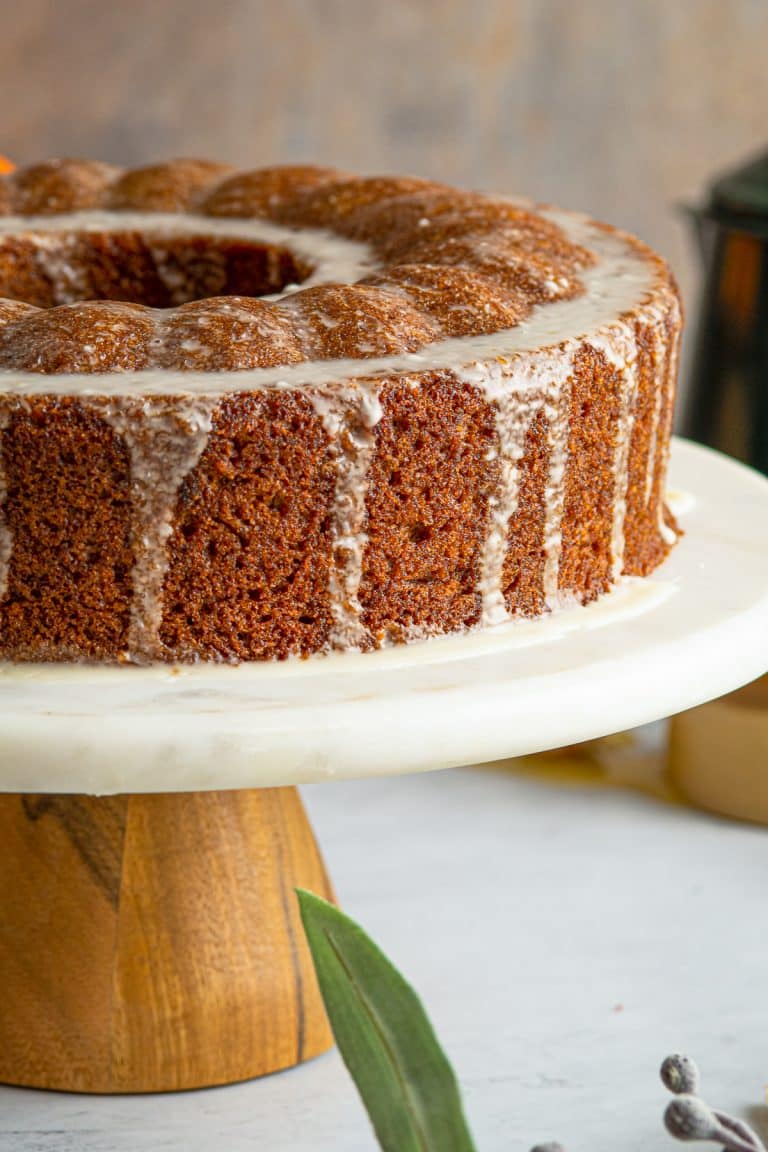 Bundt Cake on cake platter with glaze dripping down the side.