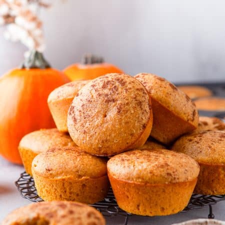 Stacked Pumpkin Cornbread Muffins on platter.