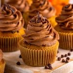 Close up of one of the Chocolate Chip Pumpkin Cupcake on wooden board frosted.