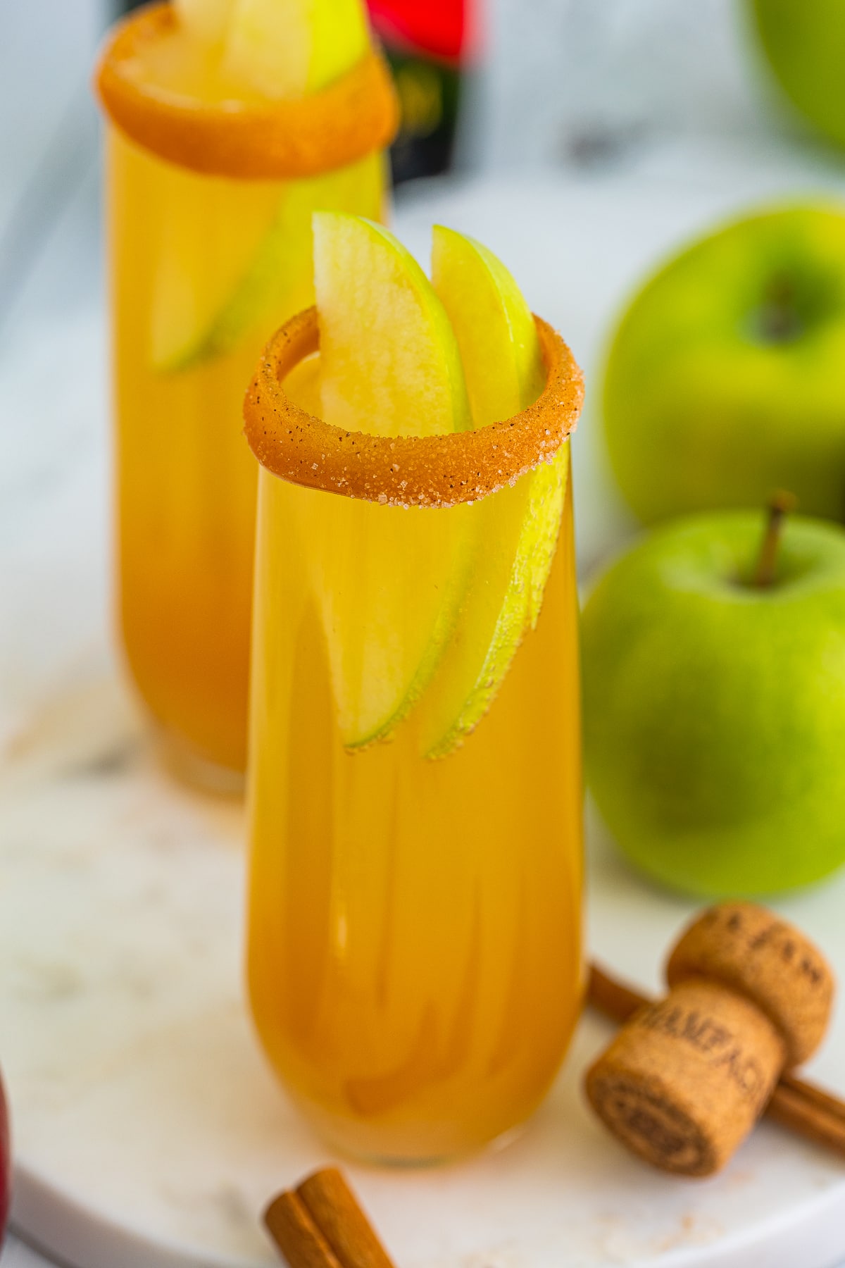 Close up of Apple Cider Mimosas with apples in glass as garnish.