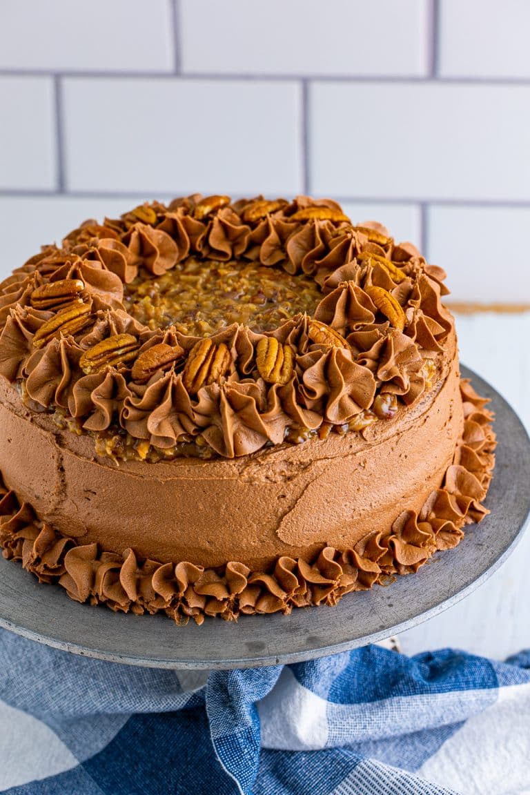 Finished cake frosted and decorated on cake stand.