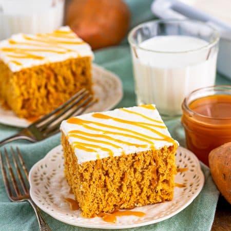 Top slices of Sweet Potato Cake on plates with caramel sauce and milk in background.