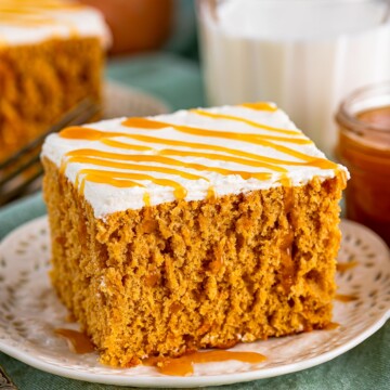 Close up of one slice of Sweet Potato Cake on white plate drizzled in caramel sauce.