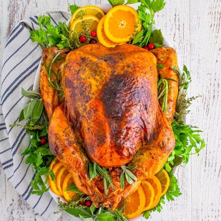Overhead of Whole Roasted Turkey finished on platter with garnishes.