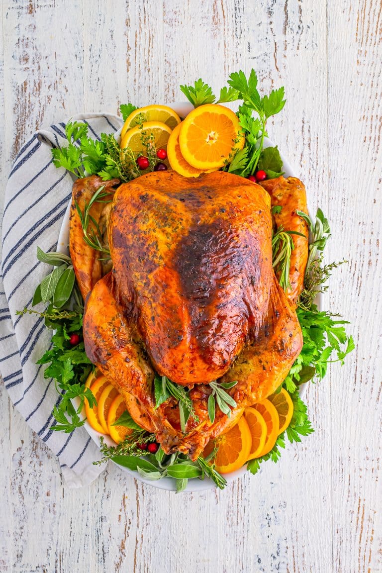 Overhead of Whole Roasted Turkey finished on platter with garnishes.