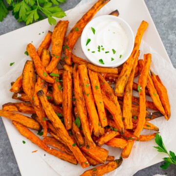 Platter of fries overhead on plate with parsley garnish.
