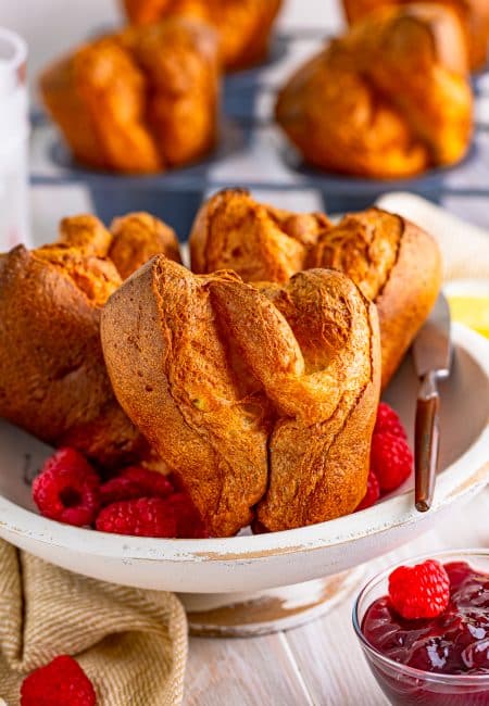 Close up of Popover Recipe in white dish with fruit in dish.