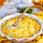 Hot Spinach Artichoke Dip in baking pan with spoon.
