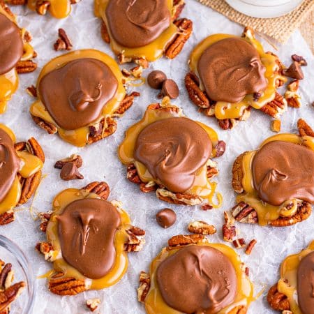 Overhead of Turtle Candy on parchment paper with pecans.