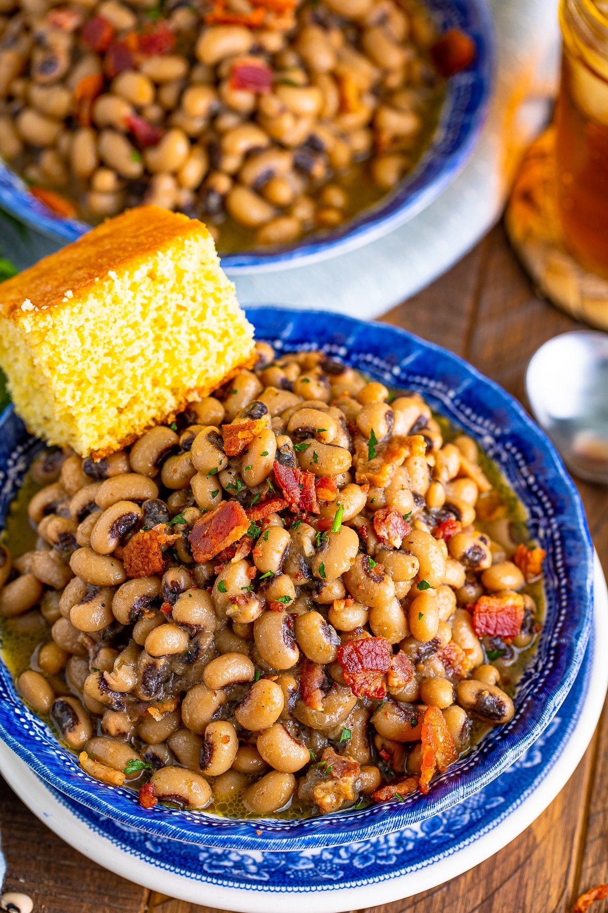 Overhead of Bacon Black Eyed Peas in bowls with cornbread.