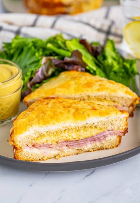 One Croque Monsieur Recipe on plate cut in half with salad.