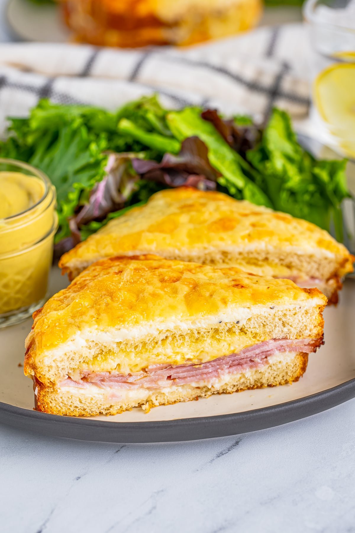 One Croque Monsieur Recipe on plate cut in half with salad.