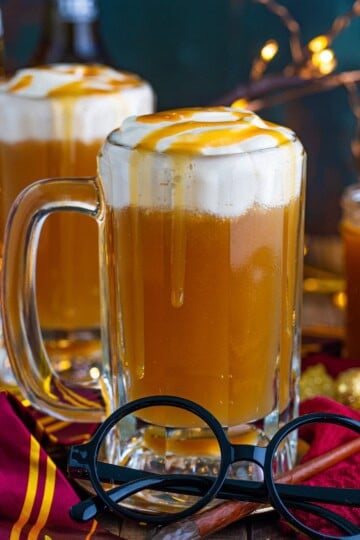 Close up of one glass of the Butterbeer Recipe with glasses in front.