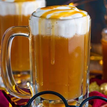 Close up of one glass of the Butterbeer Recipe with glasses in front.