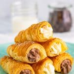 Stacked Cream Horns on turquoise plate.