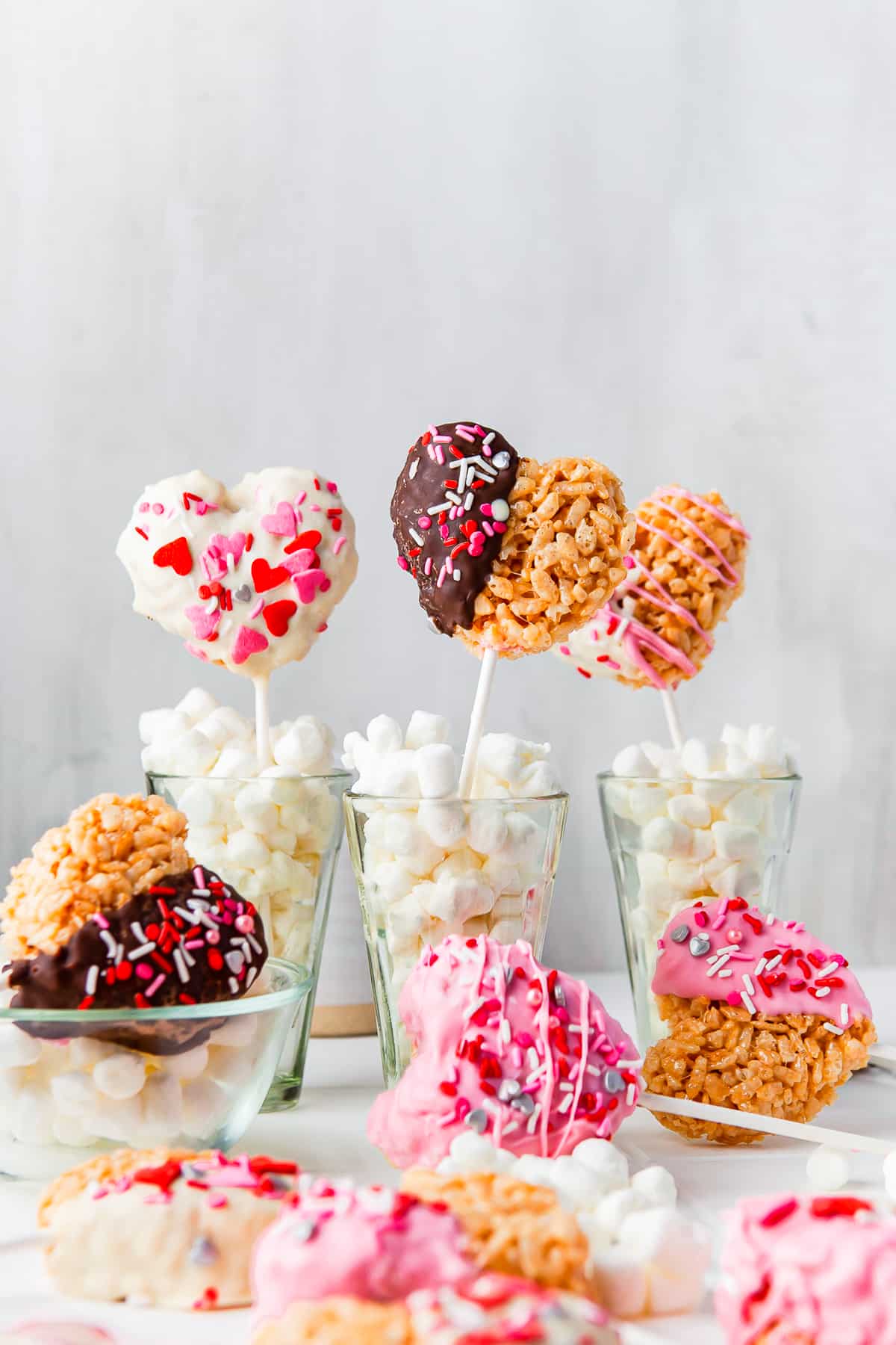 Valentines Rice Krispies Treats some in cups other laying on white board.