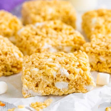 Rice Krispies Treats Recipe finished and cut into bars on parchment paper.