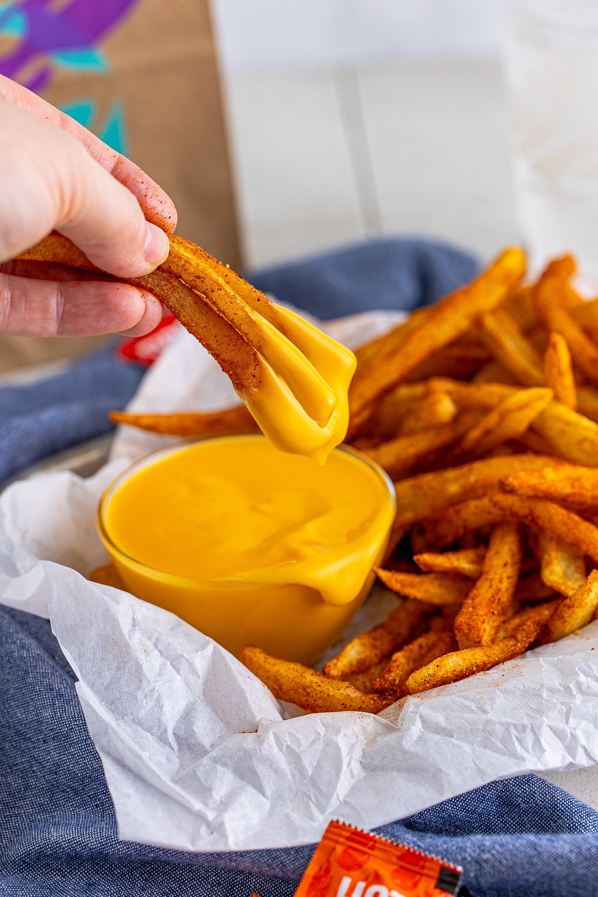 Dipped Nacho Fries Recipe shown being held in hand.