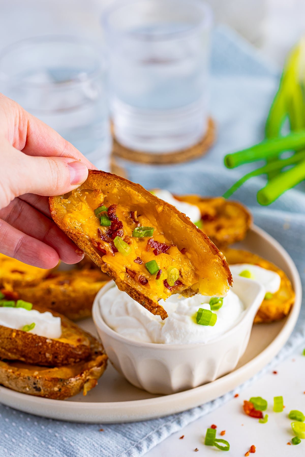Hand dipping one of the Loaded Potato Skins into sour cream.