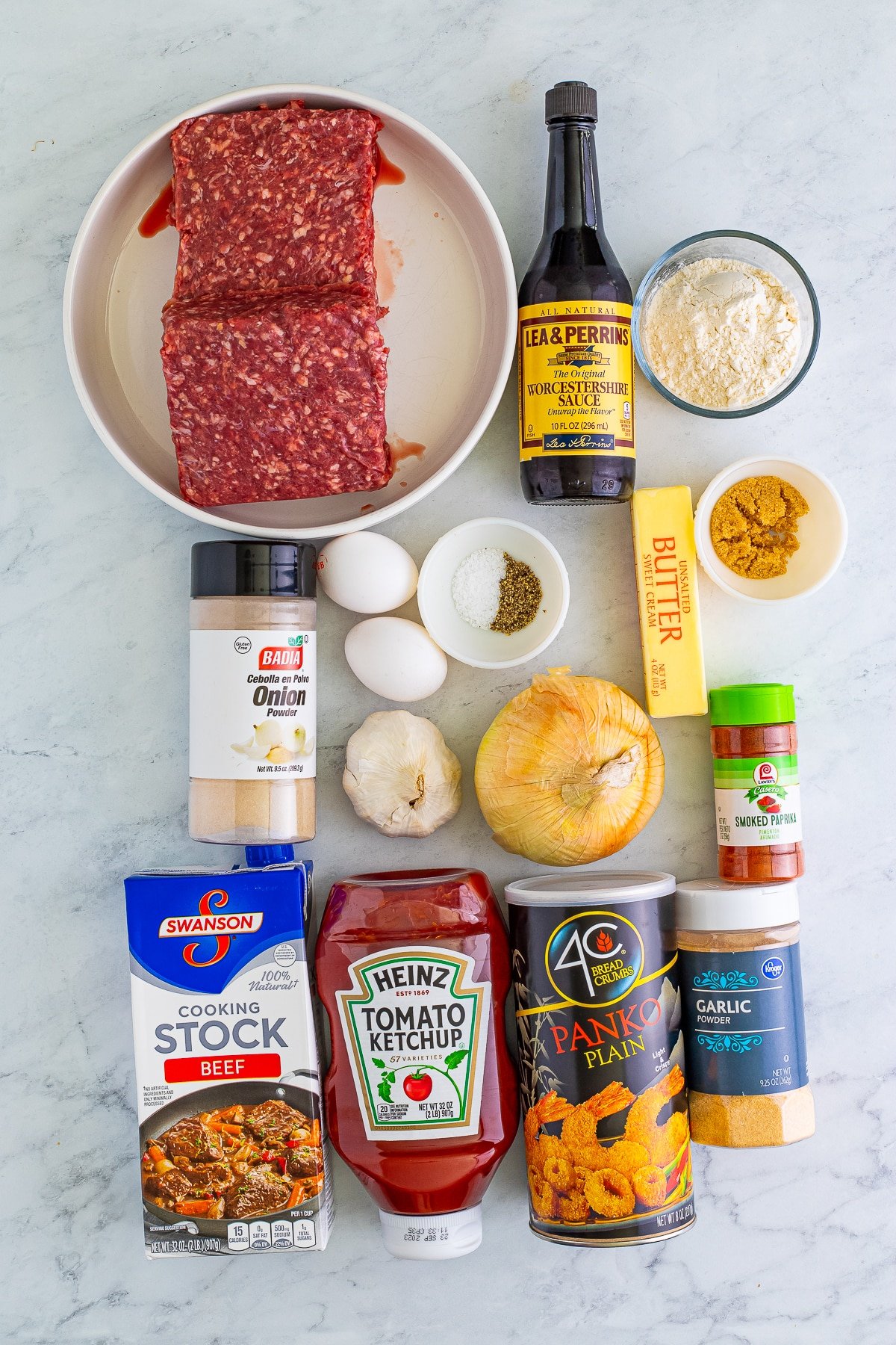 Overhead shot of ingredients needed to make Meatballs and Gravy on a grey marble tabletop