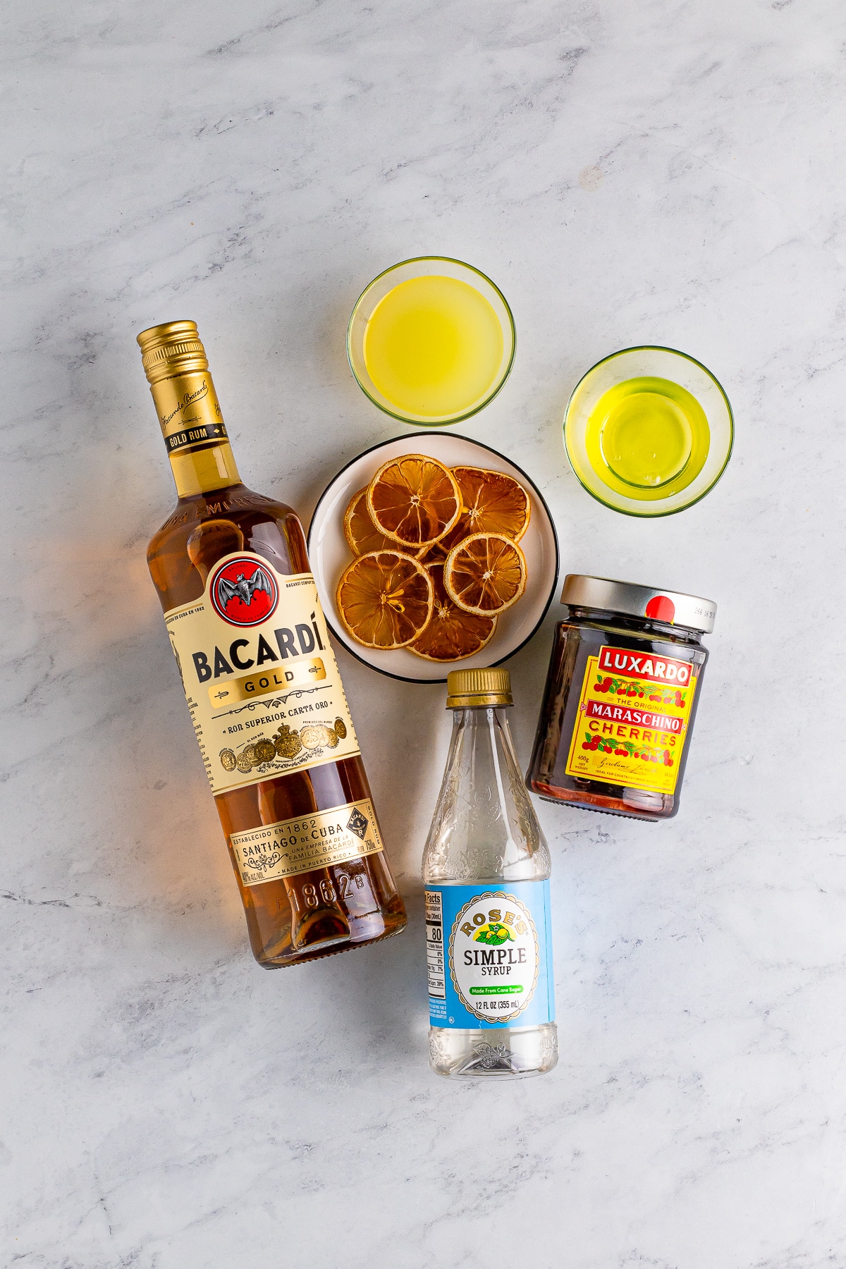Overhead image showing ingredients to make our rum sour recipe on a grey marble tabletop