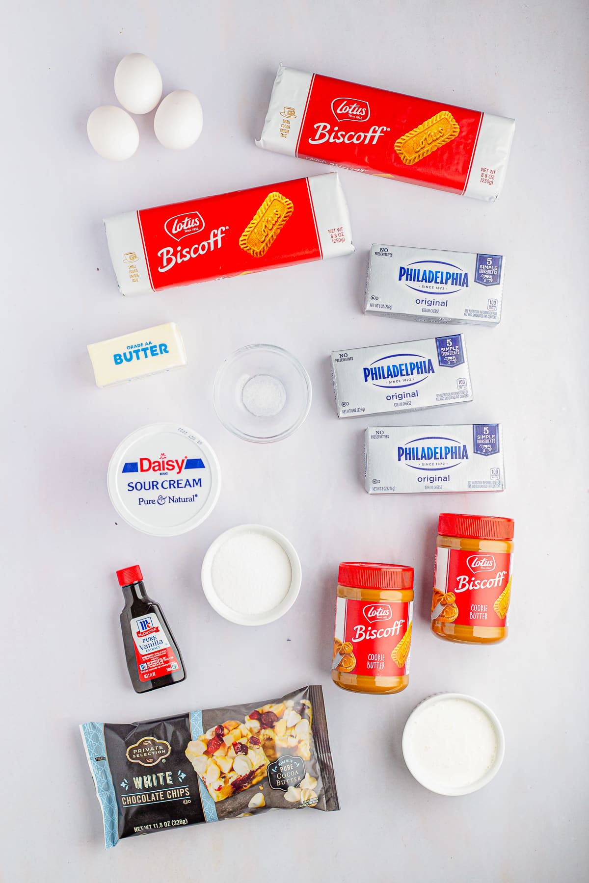 Overhead image of ingredients needed to make Biscoff Cheesecake Bars on a white table top