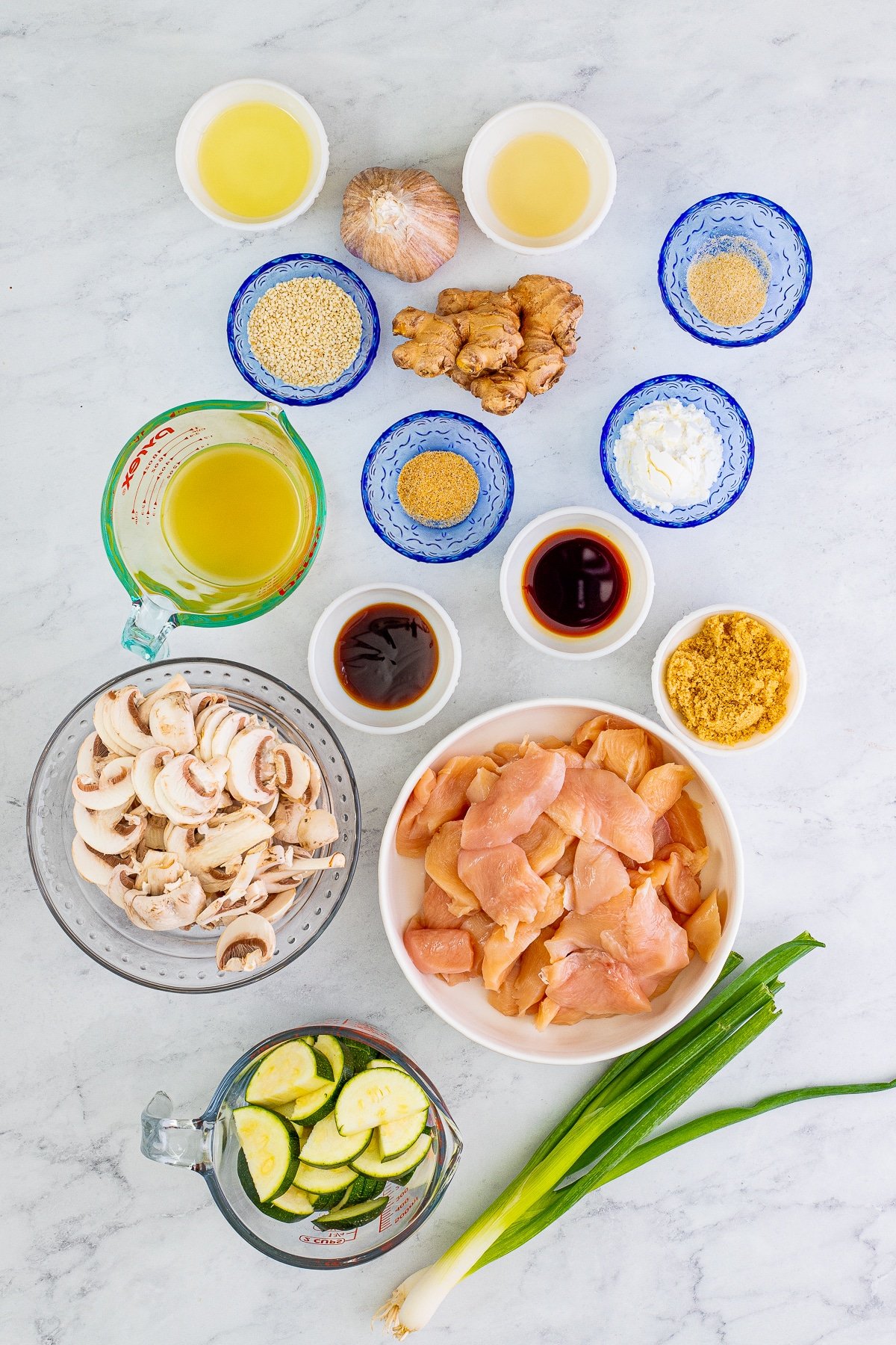 Overhead image of ingredients needed to make panda express mushroom chicken on a grey marble table top