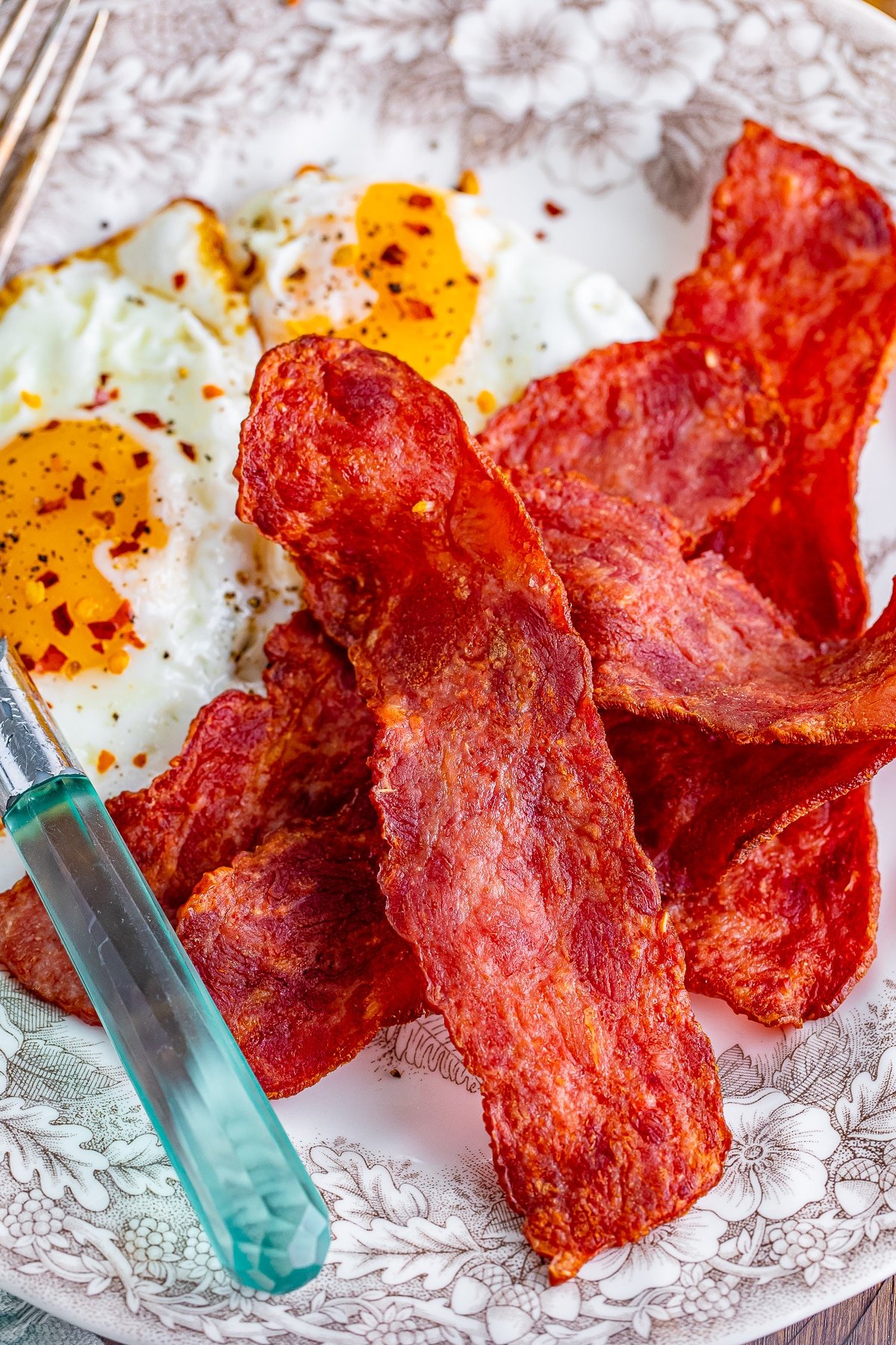 air fryer turkey bacon on a plate with fried eggs
