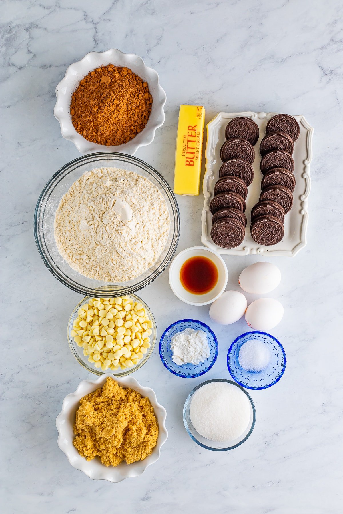 Overhead image of ingredients needed to make cookies and cream cookies on a grey marble table top