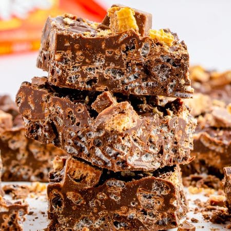 A stack of homemade Nestle crunch bars topped with chopped Kit Kats.