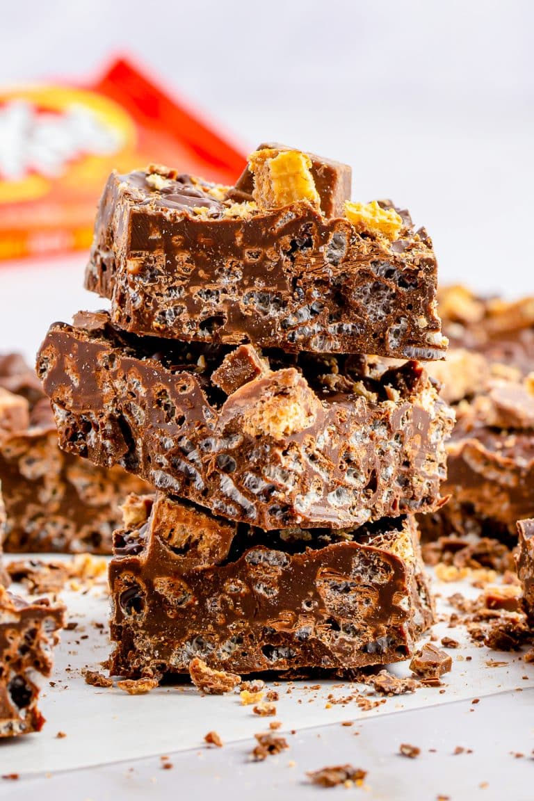 A stack of homemade Nestle crunch bars topped with chopped Kit Kats.