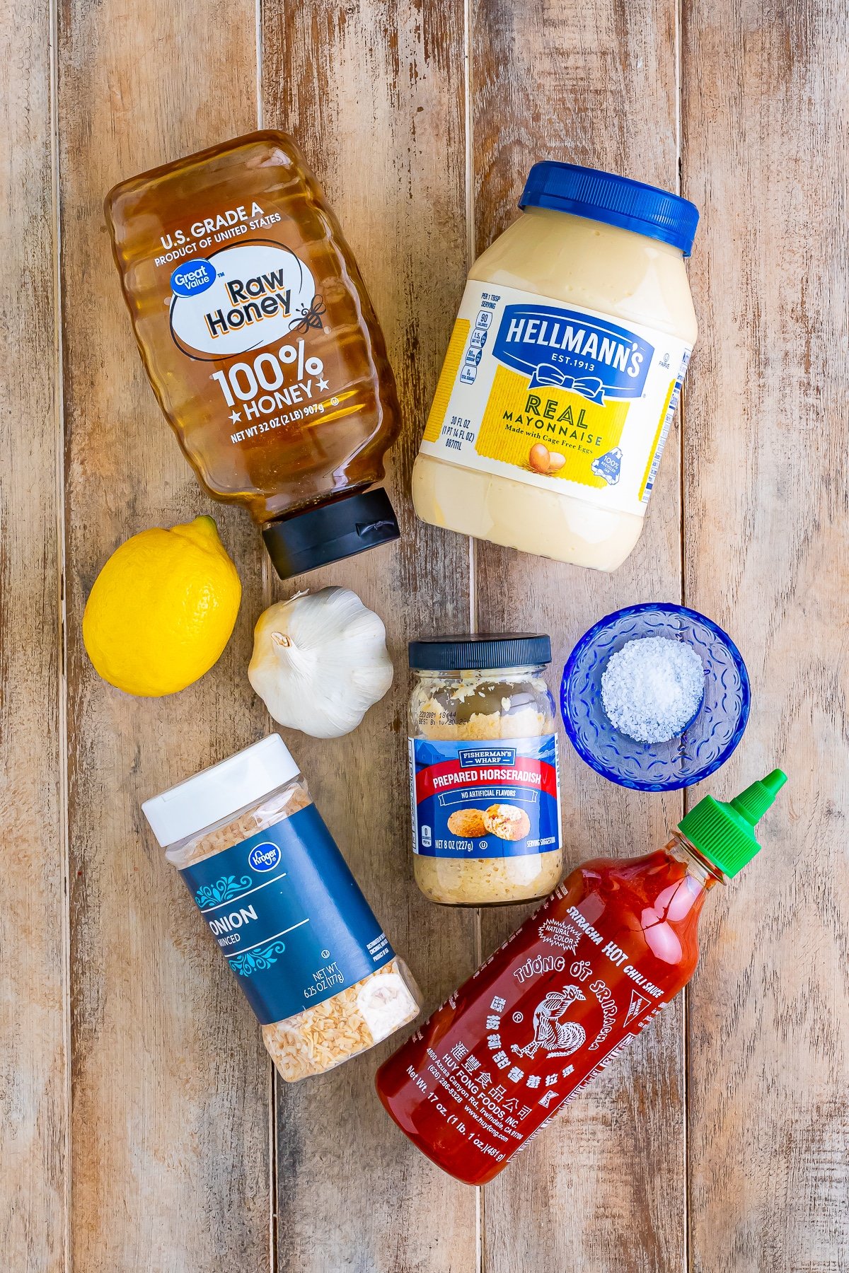 Overhead image of ingredients needed to make sriracha mayo on a wooden table top