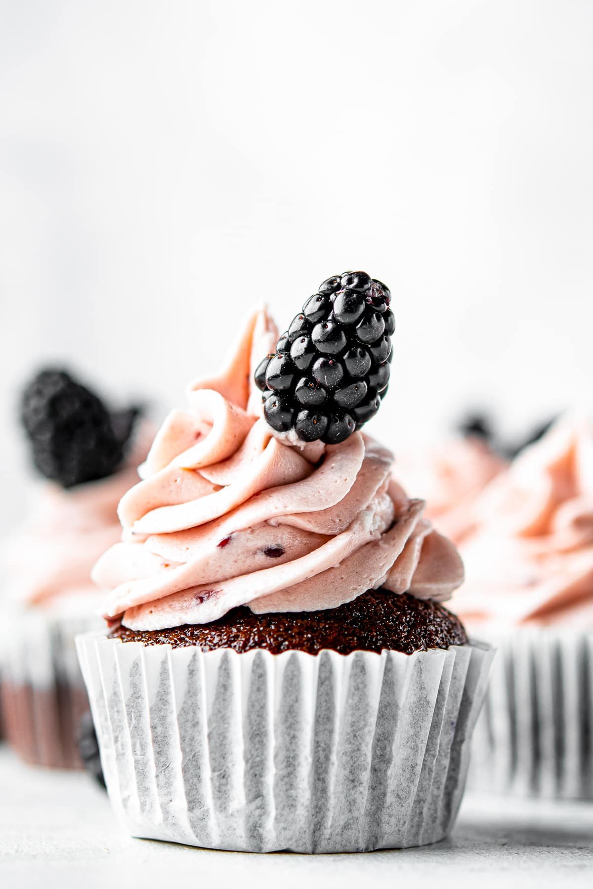 upclose image of chocolate cupcakes with blackberry buttercream