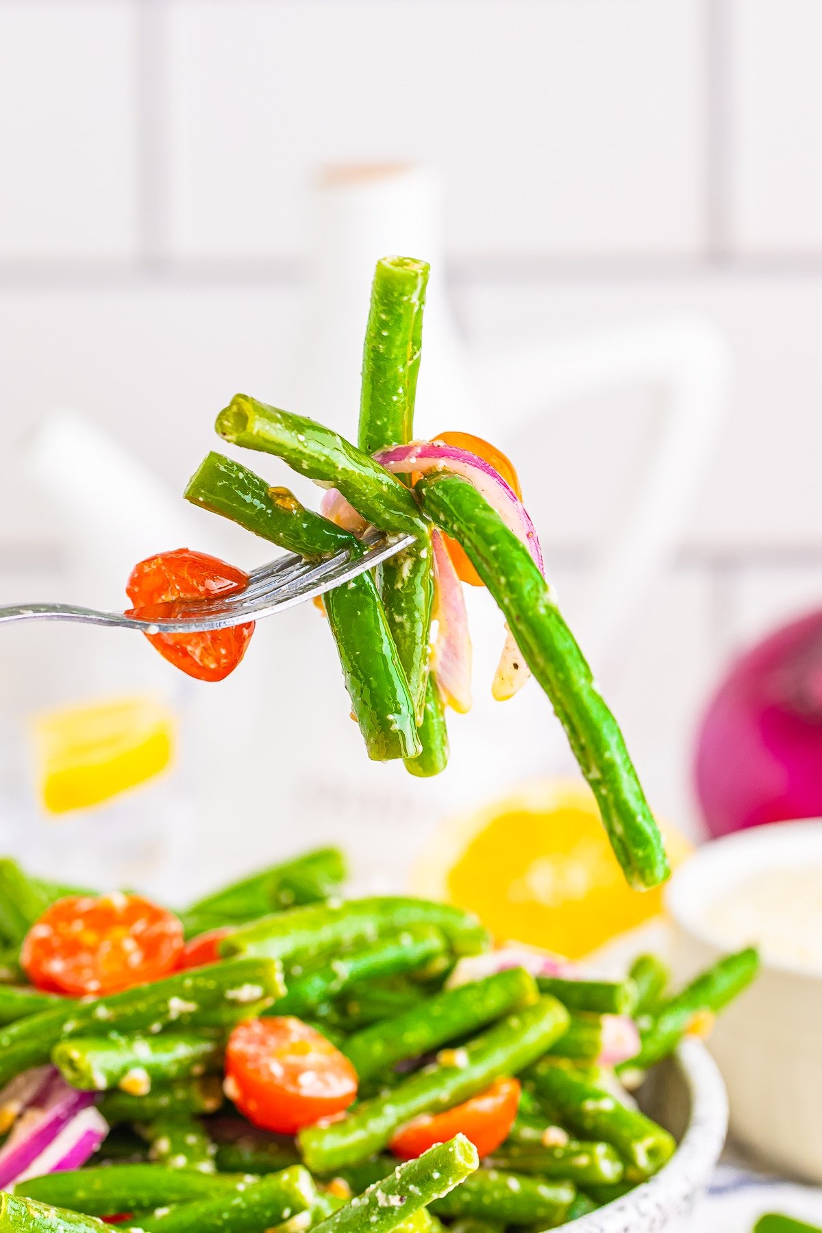a fork holding up a portion of cold green bean salad