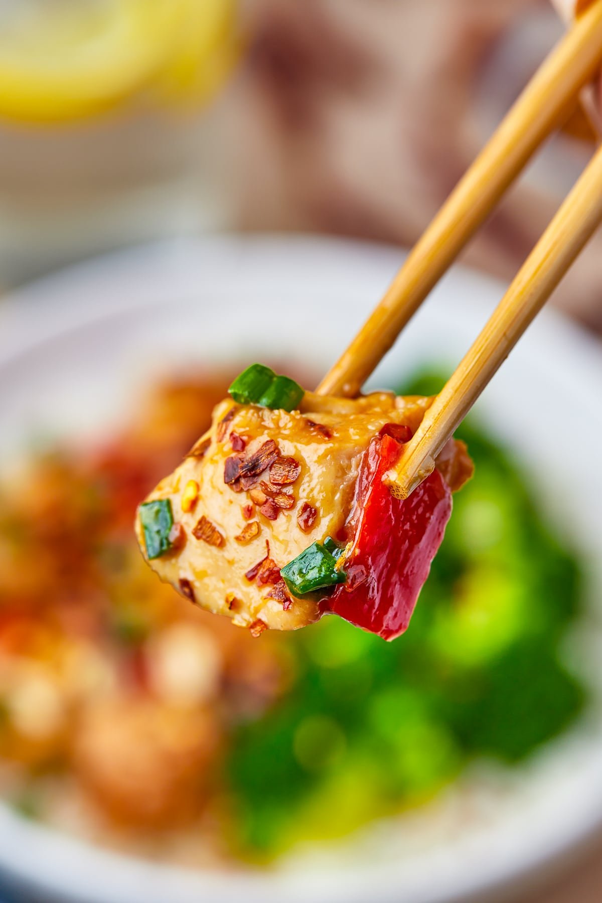 chopsticks holding a piece of kung pao recipe in air
