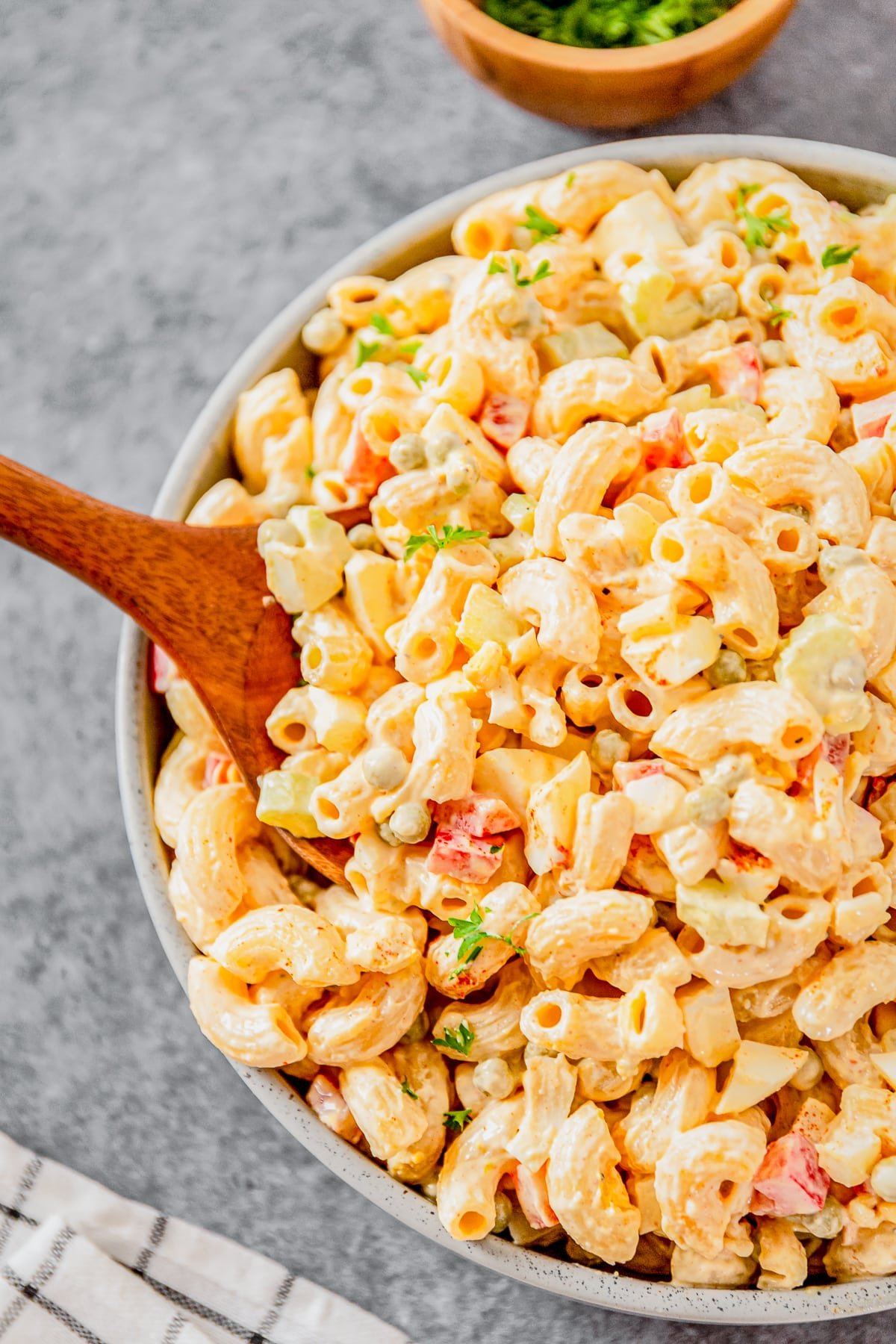 Overhead image of macaroni salad with peas with a serving spoon