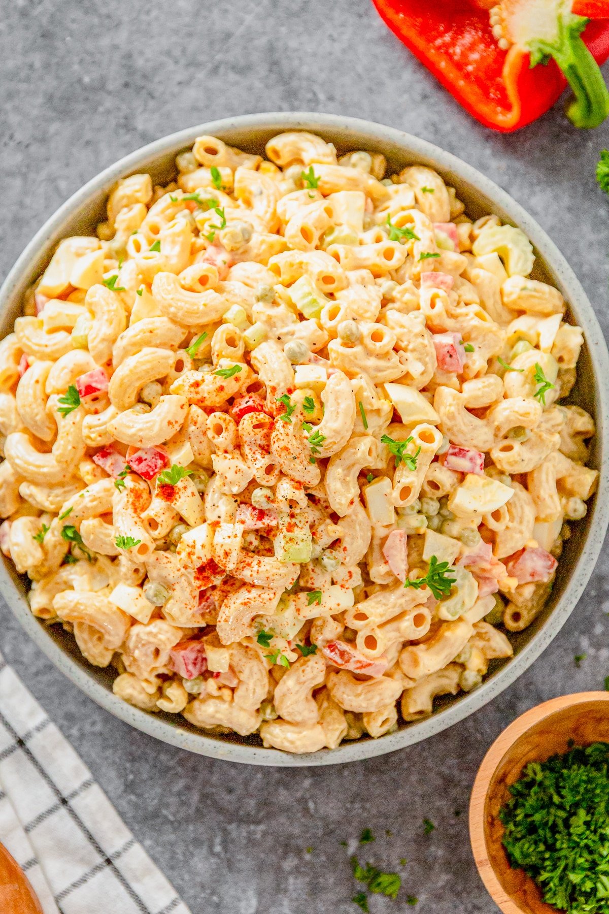 Overhead image of macaroni salad with peas in a grey bowl