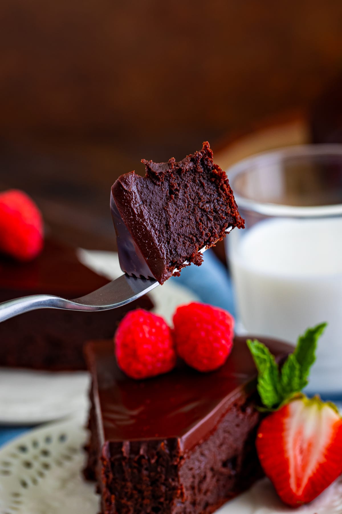 a fork holding a bite of flourless chocolate cake recipe in air