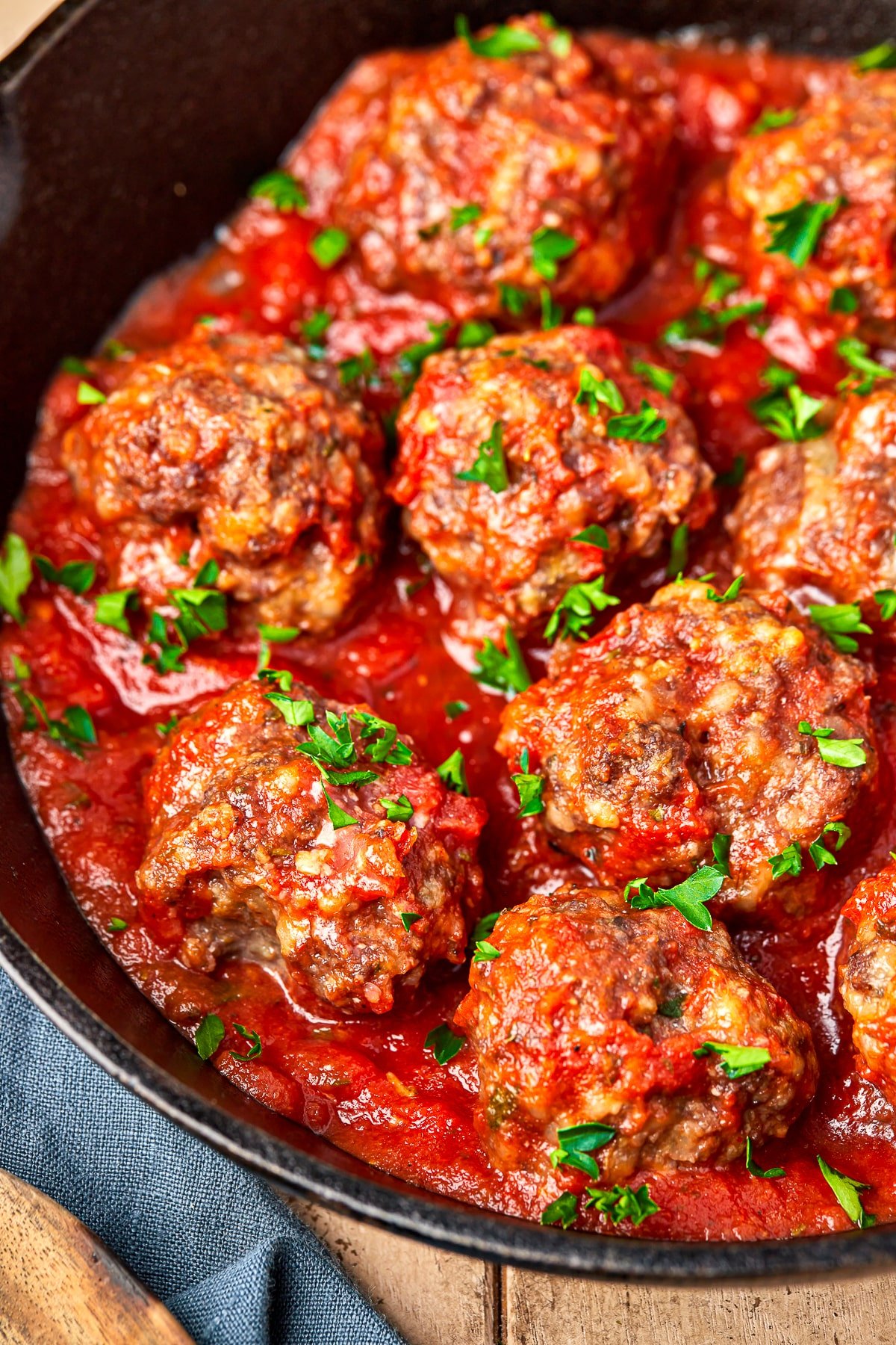 close up of baked meatballs in sauce in a skillet