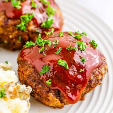 Glazed Italian mini meatloaf served on a plate with mashed potatoes.