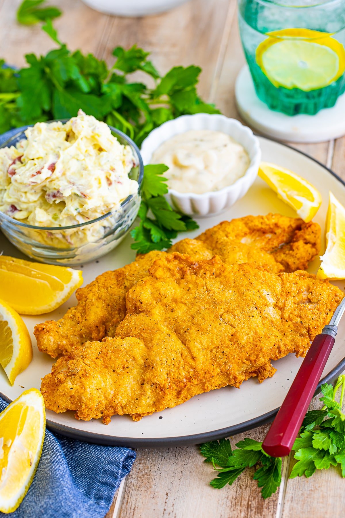 fried catfish recipe on a plate with sides