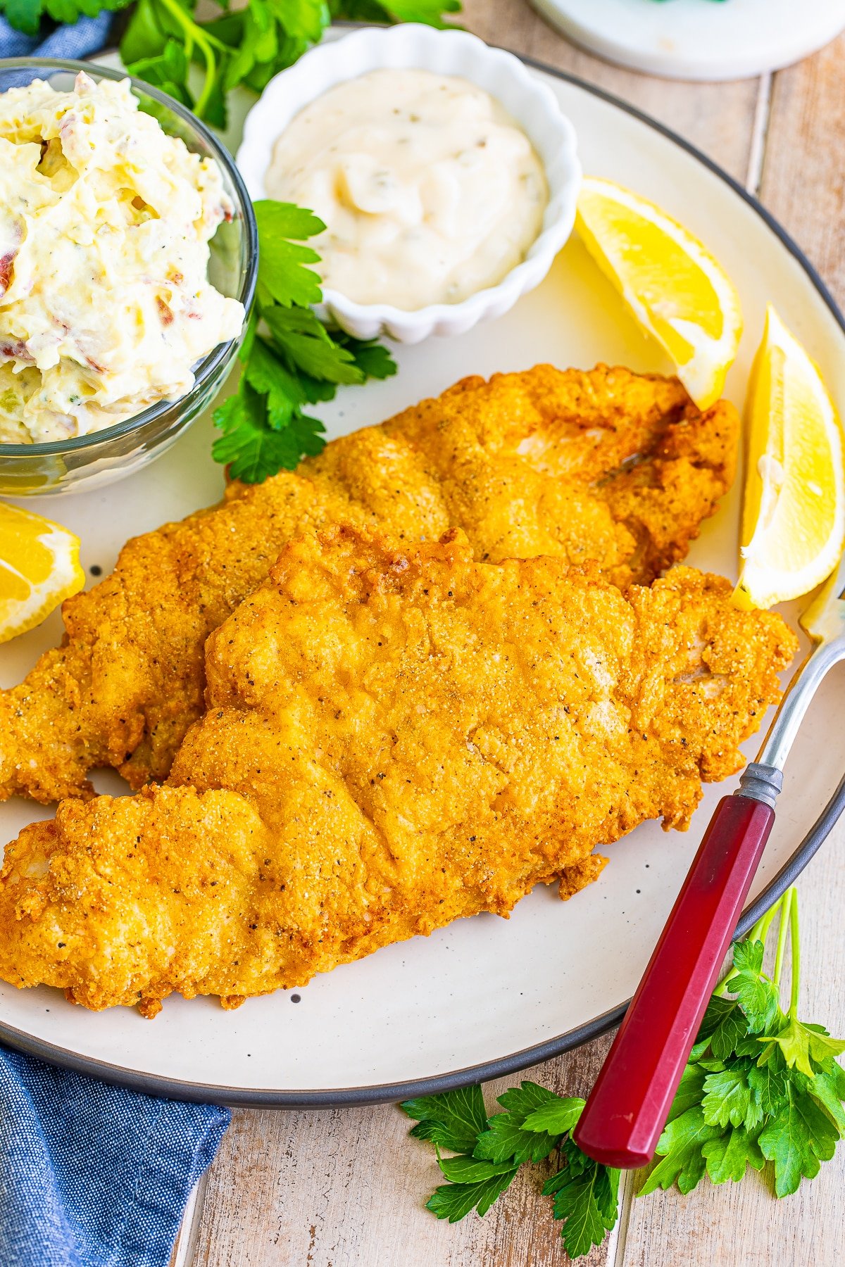fried catfish recipe on a tan plate with sides