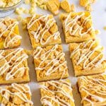 Golden Oreo cheesecake bars cut into squares with a white chocolate drizzle and crushed cookie topping.